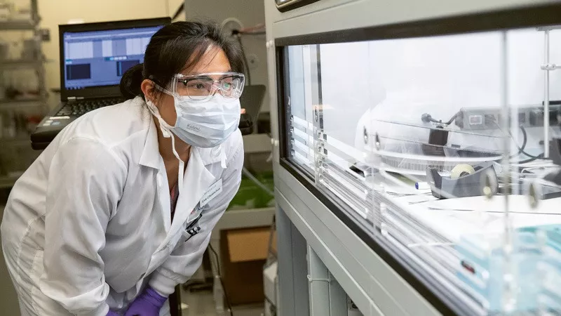 Scientist looking at mosquito machine